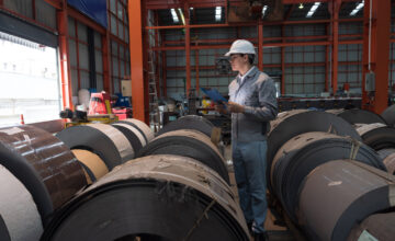An employee uses a raw materials tracker in a warehouse.