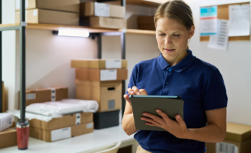 An employee uses asset management software for schools in a closet.