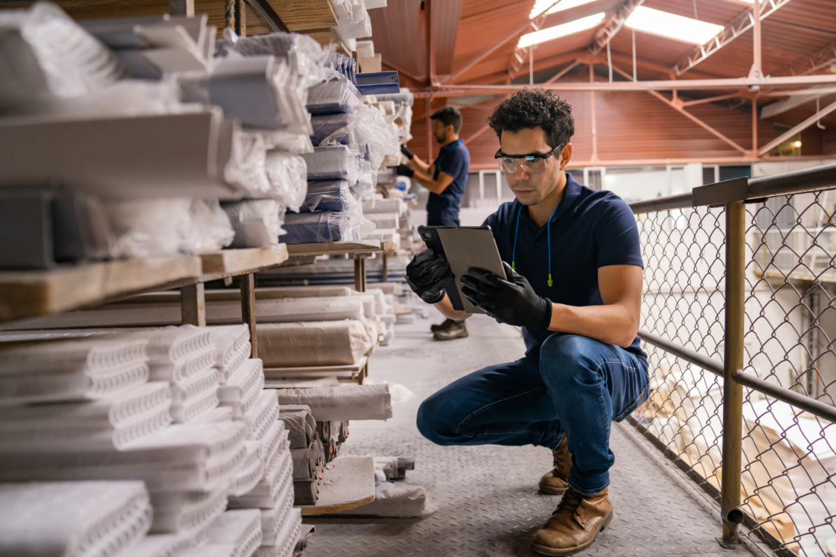 A man uses raw materials inventory management software.